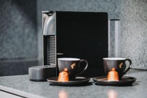 two cups on a counter with two hot dogs on plates at Fewo Mauterndorf in Mauterndorf +19 photos