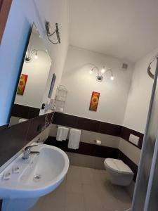 a bathroom with a sink and a toilet and a mirror at Hotel Ristorante San Michele in Ome