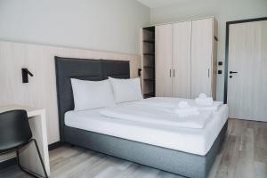 a bedroom with a large white bed and a chair at Fewo Mauterndorf in Mauterndorf