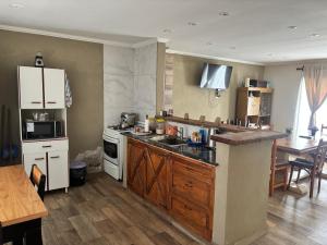 a kitchen with white appliances and a wooden floor at Alumine in Coronel Suárez