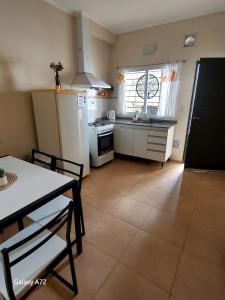 a kitchen with a table and a refrigerator and a table and chairs at Departamento Naon SP in San Pedro