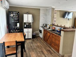 a kitchen with white appliances and a wooden table at Alumine in Coronel Suárez +10 photos
