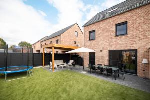a backyard with a table and chairs and an umbrella at Horse Valley in Tongeren