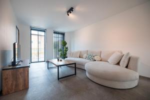 a living room with a white couch and a table at Horse Valley in Tongeren