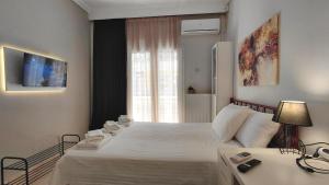 a bedroom with a large white bed and a window at Maison Centrale - Free Private Parking - Luxury Stay in Serres Center in Serres