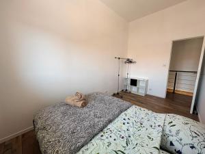 a bedroom with a bed with a stuffed animal on it at Duplex du Paradis 2 chambres in Saint-Romain-de-Jalionas