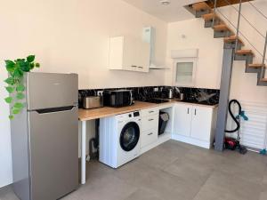 a kitchen with a refrigerator and a washing machine at Duplex du Paradis 2 chambres in Saint-Romain-de-Jalionas