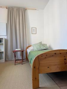 a bedroom with a wooden bed and a table at Lorenzo Apartments 05 in Burglengenfeld