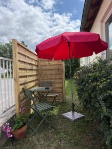 a red umbrella and a chair in the yard at Lorenzo Apartments 05 in Burglengenfeld