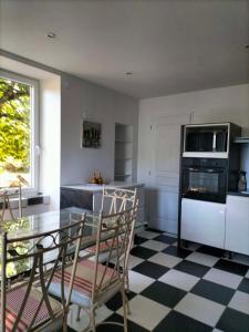 a kitchen with a table and chairs and a stove at Bienvenu chez moi 