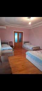 a room with three beds and a wooden floor at temo lali in Tbilisi City