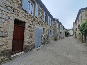 an alley with stone buildings and a brown door at T2 Concoules - Panorama, Randonnées, Etapes motards in Concoules