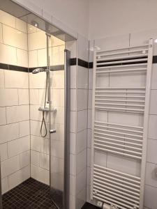 a shower with a glass door in a bathroom at Tillmanns Ankerplatz in Norden