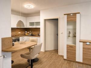 a kitchen with a table and a chair in a room at Tillmanns Ankerplatz in Norden