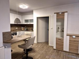 a kitchen with a table and a chair at Tillmanns Ankerplatz in Norden +1 photo