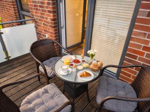 a table with breakfast food on a balcony at Tillmanns Ankerplatz in Norden