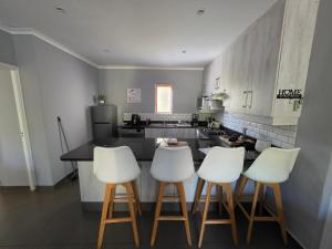 a kitchen with white bar stools and a counter at The woods at Eleven in White River