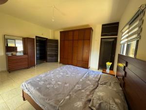a bedroom with a large bed with a wooden headboard at Countryside Guesthouse in Kafr Nabrakh
