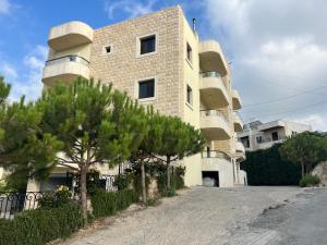 a building with trees in front of it at Countryside Guesthouse in Kafr Nabrakh +4 photos