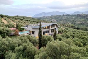 a house in the middle of a hill with trees at Autarke Ökovilla in Agios Myronas