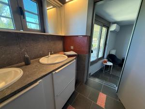 a bathroom with two sinks and a shower at Autarke Ökovilla in Agios Myronas +12 photos