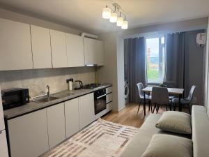 a kitchen and living room with a couch and a table at Kogălniceanu 24 in Căuşeni