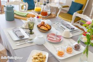 a white table with breakfast foods on it at La Maison Des Buis in Falaise