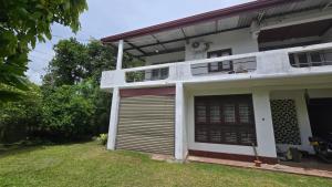 a white house with a garage and a yard at Nimna Panadura in Panadura