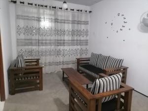 a living room with two chairs and a curtain at Nimna Panadura in Panadura
