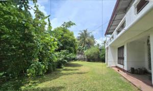 a yard next to a building with trees at Nimna Panadura in Panadura