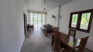 a dining room with a wooden table and chairs at Nimna Panadura in Panadura