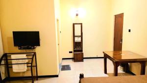 a living room with a television and a table at MARS Lodge home stay in Anuradhapura