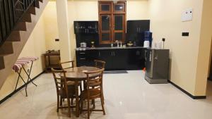 a kitchen with a table and chairs and a refrigerator at MARS Lodge home stay in Anuradhapura +4 photos