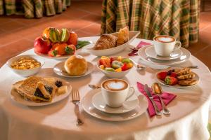 a table topped with cups of coffee and breakfast foods at Resort La Rocchetta in La Giustiniana