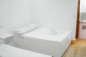 a large white bed in a white room at Quartz Suites in Camiguin