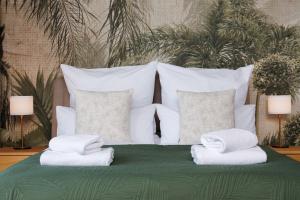 a bed with white pillows and towels on it at Svyvo Cologne - Serviced Apartments Ehrenfeld in Cologne