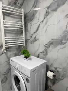 a white washing machine in a bathroom with marble walls at Kogălniceanu 24 in Căuşeni