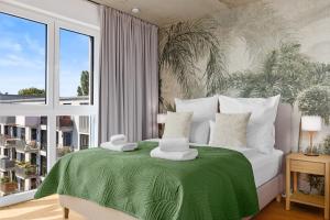 a bedroom with a large bed with a green blanket at Svyvo Cologne - Serviced Apartments Ehrenfeld in Cologne +26 photos