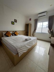 a bedroom with a large bed in a room with a window at Vang Vieng Ha Ha Hotel in Vang Vieng