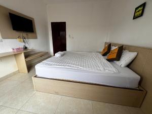 a bedroom with a large bed with a tv on the wall at Vang Vieng Ha Ha Hotel in Vang Vieng