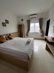 a bedroom with a large bed and a window at Vang Vieng Ha Ha Hotel in Vang Vieng