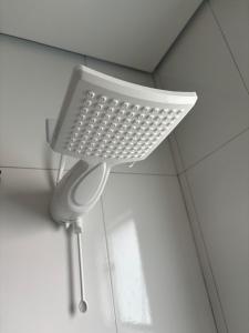 a shower head hanging from the ceiling of a bathroom at Casa completa com wifi, garagem, próximo ao centro in Piatã