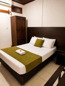 a bedroom with a large bed with a wooden headboard at Hotel Arauca Colonial in Arauca