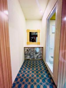 a bathroom with a mirror and a tiled floor at Saleem Resort in Skardu