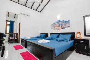 a bedroom with two beds with blue pillows at Teya Beach Ahangama in Ahangama +136 photos