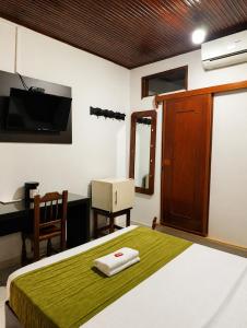 a bedroom with a bed and a desk and a television at Hotel Arauca Colonial in Arauca