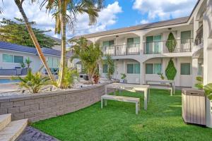 a courtyard with benches and a building at Beachside Studio w Pool Access Steps from the Shore in Pompano Beach