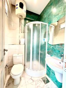 a bathroom with a shower and a toilet and a sink at منتجع أمواج الترفيهي in Ras El Bar