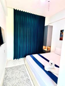 a bedroom with a bed with a blue curtain at منتجع أمواج الترفيهي in Ras El Bar