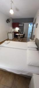 a large white bed in a room with a desk at studio in garden in Poros